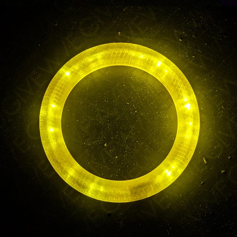 Puede incluir: Un anillo de luz LED amarillo brillante con una carcasa de pl&aacute;stico transparente. La luz de anillo est&aacute; iluminada y proyecta un brillo c&aacute;lido.