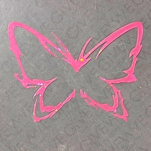 May include: A hot pink butterfly-shaped cutout featuring jagged, flame-like wing edges and a subtle holographic glitter finish that catches the light. The design is flat and symmetrical, showcasing sharp, pointed contours throughout the wings.
