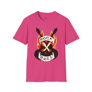 Pode incluir: Uma t-shirt magenta com um design gráfico de duas guitarras cruzadas, chamas e as palavras "ROCK ROLL" numa faixa. O design é em preto, branco e amarelo. A t-shirt é de manga curta.