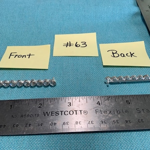 May include: A silver-toned jewelry component with clear, round stones, shown with a ruler for scale. The component is approximately 2.5 inches long. The image includes labels reading "Front", "Back", and "#63".