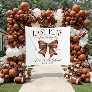 Op de afbeelding: Een decoratieve boog gemaakt van bruine en witte ballonnen, American footballs en bloemaccenten. Een witte banner toont de tekst "LAST PLAY before the big day" en "Jessica's Bachelorette, Dallas, TX."