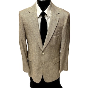 May include: A tan blazer with a textured weave, two-button closure, and notched lapels. The blazer is paired with a white dress shirt and a black tie, creating a classic, formal look. The jacket has two front pockets.