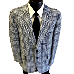 May include: A blue and white plaid blazer with a black tie. The blazer has a two-button closure and flap pockets.