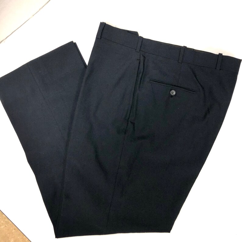 May include: Black dress pants with a single back pocket and a button closure.