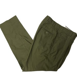 May include: A pair of olive green pants with a pleated front and a single back pocket.