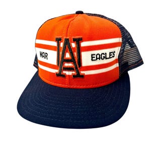 Puede incluir: Gorra de camionero naranja y azul marino con las palabras "WAR EAGLES" y una gran letra "A". La gorra tiene una parte trasera de malla y una visera curva. Una gorra de estilo clásico.