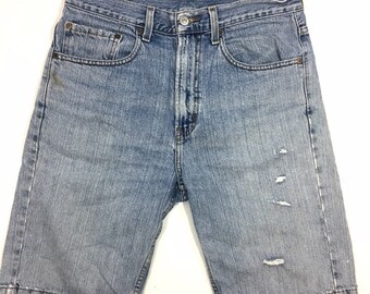 May include: Light blue denim shorts with distressed details and frayed edges.