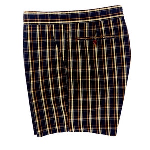 May include: Black and white checked shorts with a brown and white checked waistband. The shorts have a single back pocket.