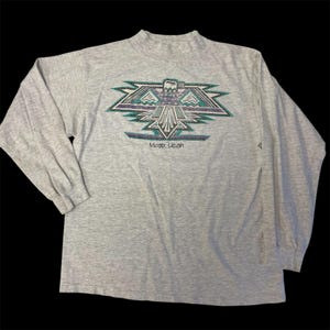 May include: Gray long-sleeve shirt with a stylized eagle graphic and the text "Moab, Utah".