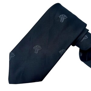 May include: A dark navy tie featuring a repeating pattern of white screw illustrations. The tie is made of a smooth fabric and is knotted, showing its full length and design.