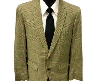 May include: A green, brown, and pink plaid blazer with a black tie. The blazer has a two-button closure and two pockets.