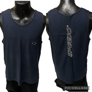 Puede incluir: Un tanque azul marino sin mangas con un logotipo de Speedo impreso en la espalda. El tanque tiene una tela texturizada.