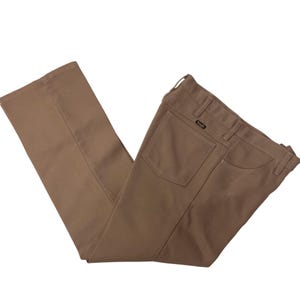 Puede incluir: Un pantalón marrón con un bolsillo trasero y una pequeña etiqueta en la parte posterior de la cintura.