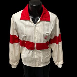 May include: White jacket with red trim and a red logo that says "PC" on the front.