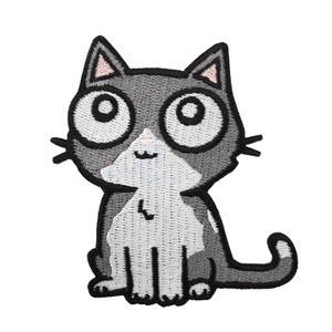 Puede incluir: Un gato de dibujos animados gris y blanco con ojos grandes y una pequeña sonrisa. El gato está sentado con la cola enroscada alrededor de sus patas.