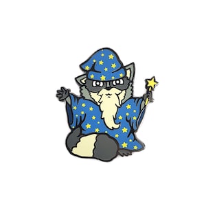 May include: A blue and yellow enamel pin of a raccoon wearing a wizard hat and holding a magic wand. The raccoon has a white beard and a serious expression.