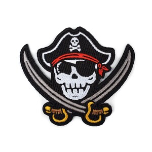 May include: Black and white embroidered patch of a skull wearing a black pirate hat with a red bandana and crossed swords.