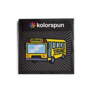May include: A yellow school bus embroidered patch with the word "STRUGGLE" on the front and back. The patch is on a black background with a white starburst pattern.