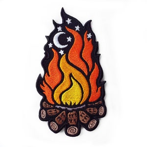 Puede incluir: Parche bordado para planchar con un fuego de campamento con llamas naranjas y amarillas, una luna creciente y estrellas sobre un fondo negro. El fuego de campamento está hecho de troncos marrones.