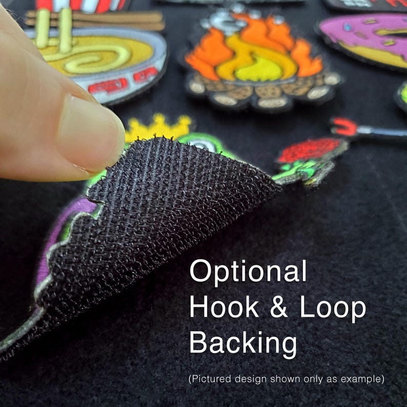 May include: A black hook and loop backing material attached to the underside of a colorful embroidered patch. The text Optional Hook & Loop Backing is printed on the black surface, with other embroidered patches visible in the background.