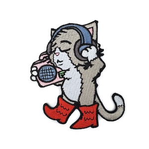 Puede incluir: Un parche bordado para planchar de un gato gris con botas rojas y auriculares, sosteniendo una radio portátil rosa.