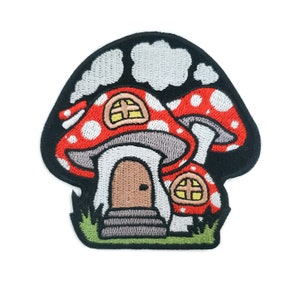May include: A red and white mushroom house with a brown door and windows. The mushroom house is surrounded by green grass.