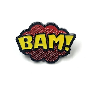 May include: A yellow "BAM!" comic book speech bubble pin with a red and black background.