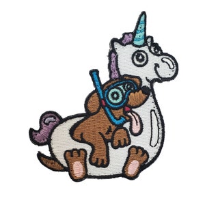 Puede incluir: Parche bordado con un unicornio blanco con un cuerno morado y un perro marrón que lleva un snorkel y gafas de buceo azules, montando sobre la espalda del unicornio.