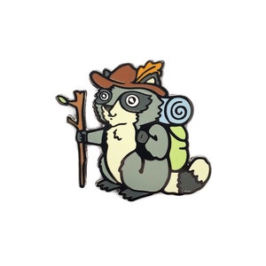 Puede incluir: Un mapache de dibujos animados con un sombrero marrón con una pluma, un saco de dormir azul y blanco y sosteniendo un palo. El mapache es gris con ojos negros y una nariz negra.