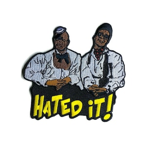May include: Embroidered patch featuring two figures in white shirts and black pants. The figures are brown-skinned with hats and bow ties. The patch has the words "HATED IT!" in yellow, outlined in black.