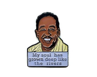 Puede incluir: Un pin de esmalte negro con una ilustración de dibujos animados de un hombre sonriente con el texto "My soul has grown deep like the rivers".