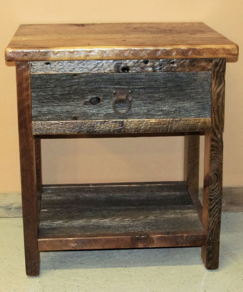 May include: A rustic wooden nightstand with a single drawer and a lower shelf. The drawer has a metal ring pull and the wood has a natural, weathered finish.