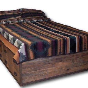 May include: A wooden bed frame with storage drawers and a patterned blanket. The bed frame is made of rustic wood with a natural finish. The blanket is a colorful southwestern design with black, brown, orange, and white stripes.