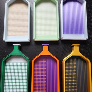 May include: Six different coloured plastic trays with grid patterns. The trays are designed for organising and sorting small items, such as beads or diamonds.