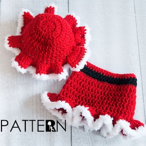May include: Red crocheted hat and skirt set with white trim. The hat has a scalloped edge and the skirt has a black waistband.
