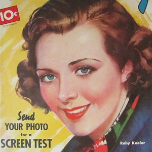 May include: A vintage magazine cover featuring a woman with dark brown hair and a red, white, and green patterned blouse. The magazine is titled "Screen Play" and has a price of 10 cents. The text "Send Your Photo for a Screen Test" is printed below the woman's image. The text "Your Chance to get in the Movies FREE See Page 26" is printed below the text "Screen Test". The woman's name, "Ruby Keeler", is printed in the bottom right corner of the cover.
