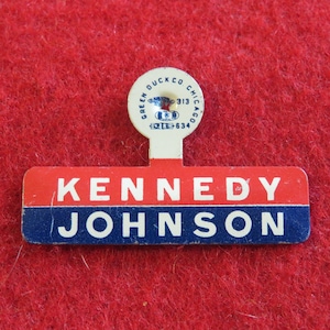 May include: A red, white, and blue campaign button with the text "KENNEDY JOHNSON" and a small round pinback with the text "GALEN DUCK CO CHICAGO 313 412-6334".