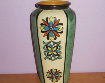 Może przedstawiać: Zielony ceramiczny wazon z białym tłem i kolorowymi wzorami kwiatowymi. Wazon ma zaokrąglone dno i wąski otwór.