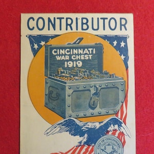 May include: A vintage poster with the text "CONTRIBUTOR" in large, bold letters. The poster features a stylized image of a metal chest with the text "CINCINNATI WAR CHEST 1919" on the lid. The chest is overflowing with gold coins. A bald eagle with outstretched wings is perched on a red, white, and blue American flag. A circular seal with the text "CITY OF CINCINNATI" is at the bottom of the poster.