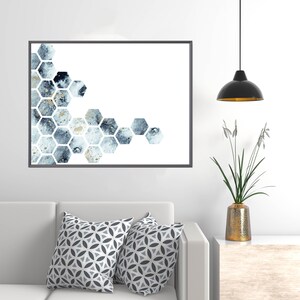 May include: A framed print of a geometric abstract design with blue and gold watercolor hexagons on a white background.