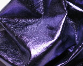 Puede incluir: Primer plano de un trozo de cuero metálico morado con una superficie lisa y brillante.