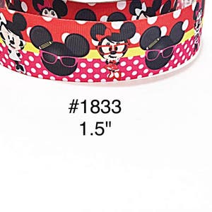 May include: Red ribbon with a white polka dot pattern and cartoon character faces. The ribbon features the text "#1833" and the measurement "1.5" in white. The ribbon has a yellow stripe.
