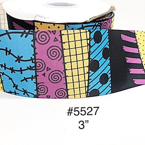 May include: A roll of patterned ribbon featuring a patchwork design in yellow, blue, black, and purple. The ribbon has a width of 3 inches and includes the text "#5527".