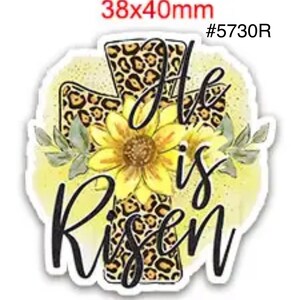 May include: A sticker featuring a cross with a leopard print design, a yellow sunflower, and the words "He is Risen" in black script. The sticker measures 38x40mm.