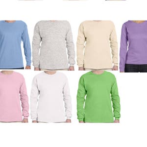 May include: Eight long-sleeved t-shirts in different colors: light blue, grey, beige, purple, pink, white, green, and black.