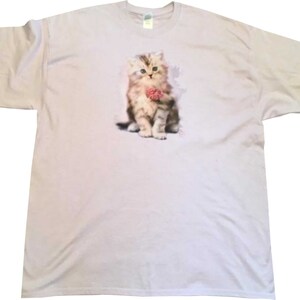May include: A lavender t-shirt with a graphic of a cute kitten holding a pink ball of yarn.