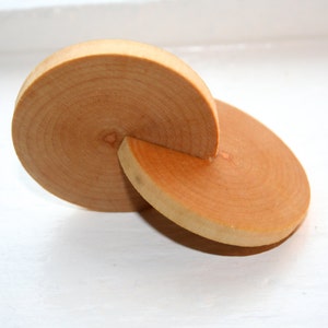 May include: Two wooden circles, one partially overlapping the other, creating a unique shape. The circles are made of light brown wood with visible grain patterns.