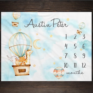 May include: A blue and white hot air balloon with a giraffe, fox, and elephant inside. The balloon is surrounded by clouds and stars. The text "Austin Peter" is written above the balloon. Below the balloon are numbers 1 through 12, representing months. The text "months" is written below the numbers.