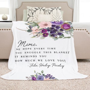 May include: White throw blanket with a floral design in shades of purple and pink. The blanket has a personalized message that reads "Mimi, We hope every time you snuggle this blanket it reminds you how much we love you! -Julia. Hailey. Paisley"