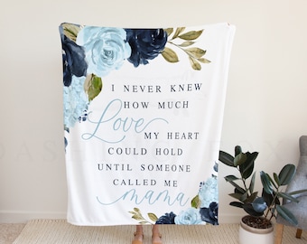 May include: White throw blanket with a floral design in shades of blue and green. The blanket features the text "I never knew how much love my heart could hold until someone called me mama."